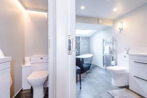 a white bathroom with a toilet and a sink at Cosy Lake District Cottage - Walk to Windermere - Sleeps 6 in Windermere