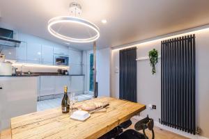 a kitchen with a wooden table with a bottle of wine at Cosy Lake District Cottage - Walk to Windermere - Sleeps 6 in Windermere
