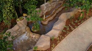 a fake river in a garden with a waterfall at Crystal Falls Wayanad in Wayanad