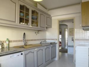 a kitchen with white cabinets and a sink at Humen apartamento T2 in Tavira +5 photos