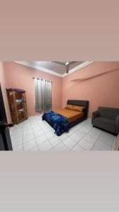 a bedroom with a bed and a couch in a room at LOT 1423 Homestay Lonek-Batu Kikir in Bahau