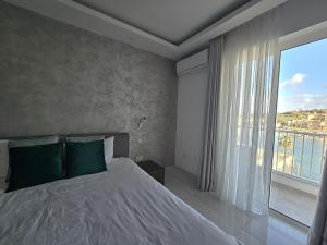 a bedroom with a bed and a large window at SouthShore Accommodation in Marsaskala
