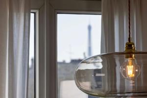 a glass lamp hanging in front of a window at Hôtel de Banville in Paris