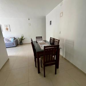 a dining room with a table and chairs and a couch at Cantinho 108 in São Luís +11 photos