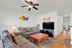 a living room with a couch and a flat screen tv at Tybee Turtle in Tybee Island