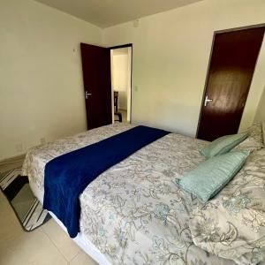 a bedroom with a large bed with a blue blanket at Cantinho 108 in São Luís