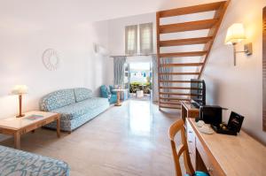 a living room with a blue couch and a staircase at Mitsis Norida in Kardamaina