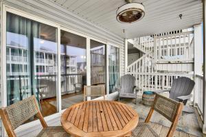 a porch with a wooden table and chairs at Tybee Turtle in Tybee Island