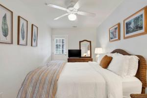 a bedroom with a bed and a ceiling fan at Tybee Turtle in Tybee Island +27 photos