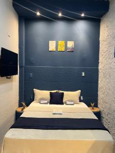 a bedroom with a large bed with a blue wall at Pousada É de casa unidade 02 apto 01 in Juazeiro do Norte