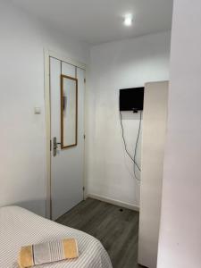 a room with a bed and a door with a mirror at Avenue Rooms in Valencia