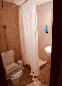 ein Badezimmer mit weißem Duschvorhang und Toilette in der Unterkunft Hotel Strimoniko in Asprovalta + 89 Fotos