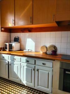 a kitchen with white cabinets and a counter top at Casa do Pinhal in Moledo