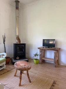 a living room with a fireplace and a table with a stool at Casa do Pinhal in Moledo
