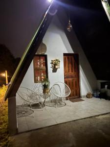 a patio with chairs and a table and a door at Elshadaychale in Ibiúna
