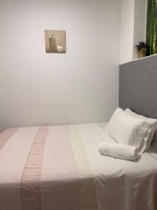 a bedroom with a bed with white sheets and pillows at Apartamento Kalea Dany in Vitoria-Gasteiz