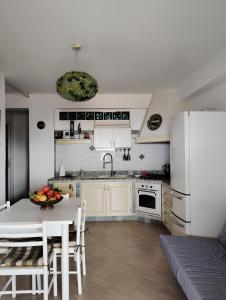 a kitchen with a table and a white refrigerator at Raggi di Sole in Custonaci