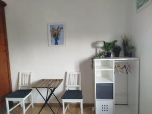 a room with two chairs and a table and a shelf at Treehouse - Spacious Private Rooms in Central Pisa Near Station & Airport in Pisa