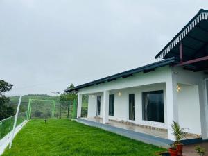 a view of a house with a yard at Bison Trails Valley View Kothagiri Ooty Tamilnadu in Kotagiri