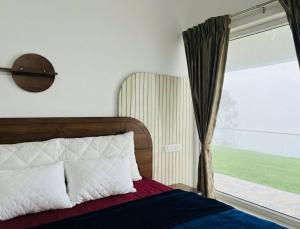 a bedroom with a bed and a window at Bison Trails Valley View Kothagiri Ooty Tamilnadu in Kotagiri +9 photos