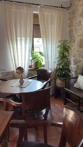 a dining room with a table and chairs and plants at Eco de las Cuevas in Santillana del Mar