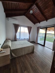 a bedroom with a bed and a large window at Quintasdeconde in San Miguel del Monte +12 photos
