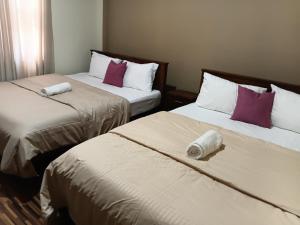 two beds in a hotel room with towels on them at Yemi Bungalow Ella in Ella