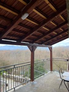 a porch with a table and chairs on a balcony at Skadar Lake Stone House in Podgorica