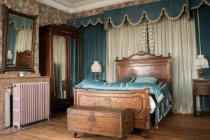 a bedroom with a large bed with a wooden frame at La Maison Coloniale - 15 Personnes - Piscine in Artagnan +90 photos