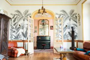 a living room with a couch and a table at La Maison Coloniale - 15 Personnes - Piscine in Artagnan