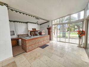 a kitchen with a sink and a large window at La Maison Coloniale - 15 Personnes - Piscine in Artagnan