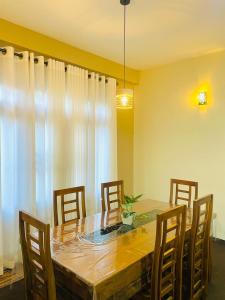 a dining room with a wooden table and chairs at Yemi Bungalow Ella in Ella