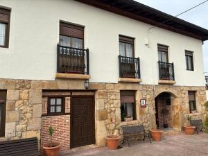 a stone house with a brown door and windows at Eco de las Cuevas in Santillana del Mar