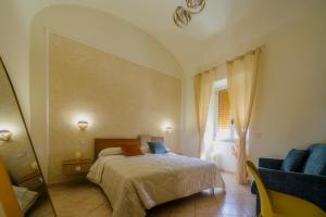 a bedroom with a bed and a chair and a window at Domus Gargilius in Pompei
