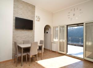 a dining room with a table and a television on a wall at Raggio di Sole Suite in Valmontone