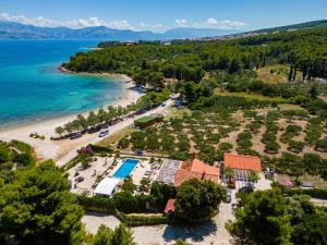 an aerial view of a resort and a beach at Beachfront House Mir Brač near Supetar with pool and jacuzzi in Mirce