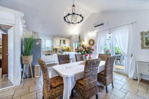 a dining room with a white table and chairs at Beachfront House Mir Brač near Supetar with pool and jacuzzi in Mirce