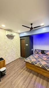 a bedroom with a bed and a ceiling fan at 7 Star Hotel in Surat