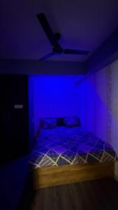 a dark room with a bed with a blue light at 7 Star Hotel in Surat +2 photos
