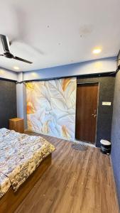 a bedroom with a large painting on the wall at 7 Star Hotel in Surat