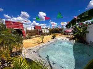 a swimming pool in a yard with houses and flags at Las siete lunas in Ucú