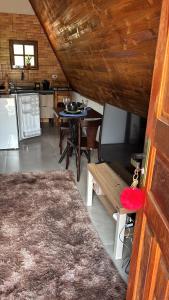 a living room with a table and a kitchen at Elshadaychale in Ibiúna