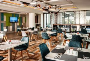 a restaurant with tables and chairs and a flat screen tv at StayEasy Maputo in Maputo