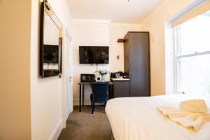a bedroom with a bed and a desk and a window at Superb Seafront Studio in Dublin