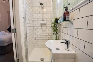 a small bathroom with a sink and a shower at Superb Seafront Studio in Dublin +8 photos