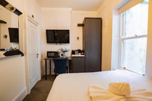 a bedroom with a bed and a desk and a window at Superb Seafront Studio in Dublin