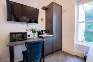 a room with a desk with a microwave and a television at Superb Seafront Studio in Dublin