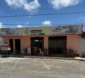 a restaurant with tables and chairs outside of a building at Apartamento de Denise in Aracaju