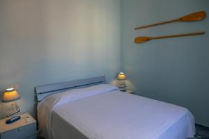 a bedroom with a bed and two night stands with lamps at Perla Marina - HelloElba in Portoferraio