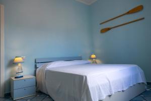 a bedroom with a bed with a blue wall at Perla Marina - HelloElba in Portoferraio